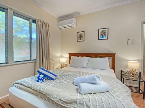 - une chambre avec un lit et des serviettes dans l'établissement Picnic Bay Apartments Unit 1, à Picnic Bay