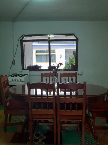 mesa de comedor con 2 sillas y ventana en Hotel Posada Doña Maria Esther en Zacatlán