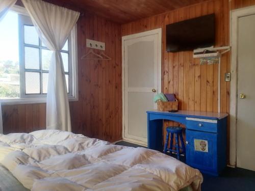 1 dormitorio con cama, escritorio y ventana en Habitación Oda al Amor de la Estancia en El Quisco