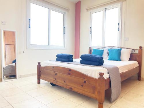 Sunset Pearl Holiday Villa في أيا نابا: غرفة نوم عليها سرير ومخدات زرقاء