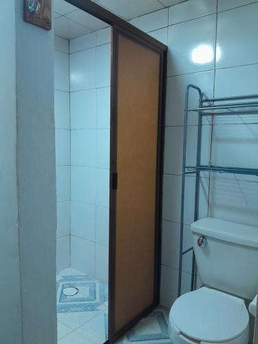 a bathroom with a toilet and a glass door at Hotel Posada Doña Maria Esther in Zacatlán