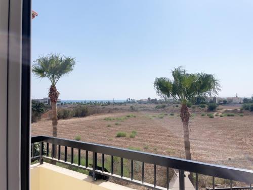 a view of a field from a balcony with palm trees at Sunset Pearl Holiday Villa in Ayia Napa