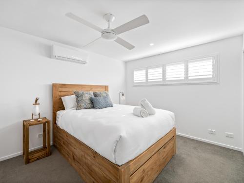 a bedroom with a large bed with a ceiling fan at Beach City 3 Bedroom Modern Townhouse in Maroochydore
