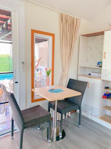 a dining room with a table and two chairs at ปูณิสาวิลล่าPoonisavilla in Ban Khlong Kao (6)