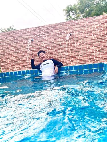 a man is standing in a swimming pool at ปูณิสาวิลล่าPoonisavilla in Ban Khlong Kao (6)