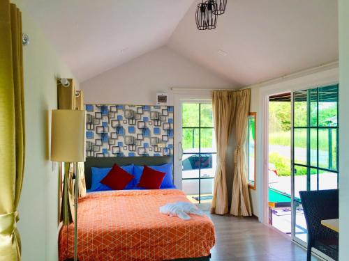 1 dormitorio con 1 cama con almohadas rojas y azules en ปูณิสาวิลล่าPoonisavilla en Ban Khlong Kao (6)
