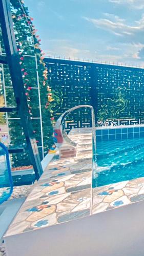 a swimming pool with stairs next to a building at ปูณิสาวิลล่าPoonisavilla in Ban Khlong Kao (6)