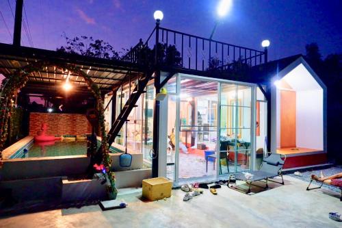 ein Glashaus mit einem Wohnzimmer und einem Pool in der Unterkunft ปูณิสาวิลล่าPoonisavilla in Ban Khlong Kao (6)