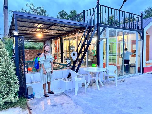 a woman is standing in front of a house at ปูณิสาวิลล่าPoonisavilla in Ban Khlong Kao (6)