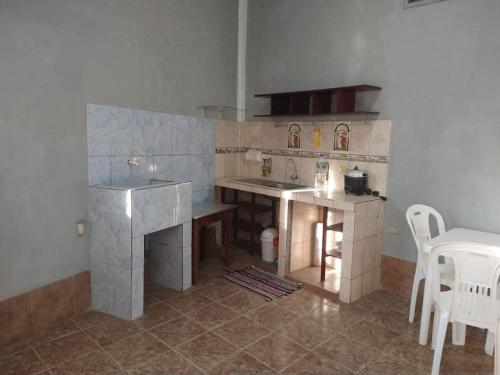 een keuken met een wastafel en een tafel met stoelen bij Descansa antes de ir a Iquitos in Yurimaguas