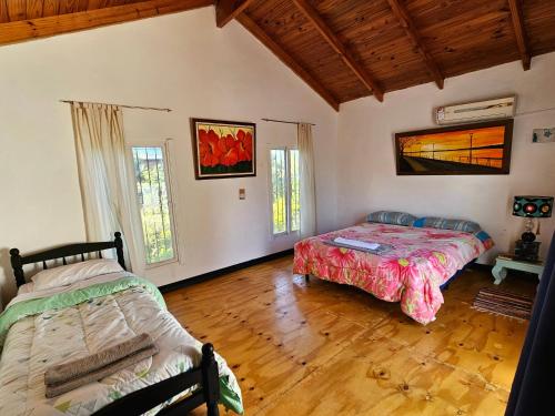a bedroom with two beds in a room with wooden floors at La joyita in Ituzaingó
