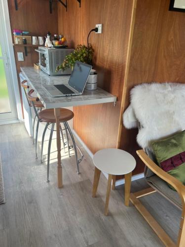 a kitchen with a table and a laptop on a counter at Waiora cottage in Otaki