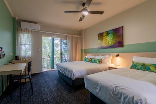 Habitación de hotel con 2 camas, escritorio y ventana en Nightcap at Waterfront Hotel en Maroochydore