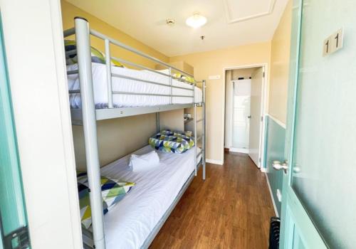 a hallway with two bunk beds in a room at Stay Hostel Rotorua in Rotorua