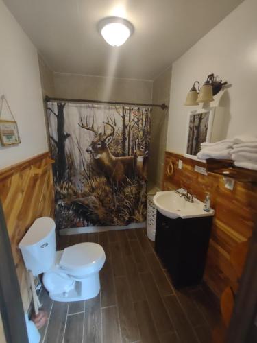 a bathroom with a deer mural on the wall at Tranquil Waters Cabin in Frenchburg