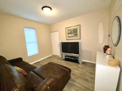a living room with a couch and a flat screen tv at Downtown Hobart Cozy 1 Bedroom in Hobart