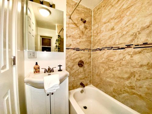 a bathroom with a sink and a bath tub at Downtown Hobart Cozy 1 Bedroom in Hobart