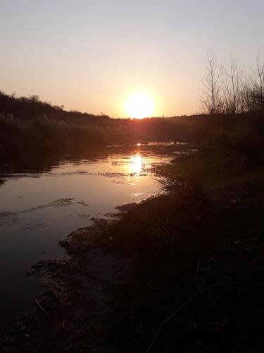 a sunset over a river with the sun setting at Casa en Cabalango in Cavalango