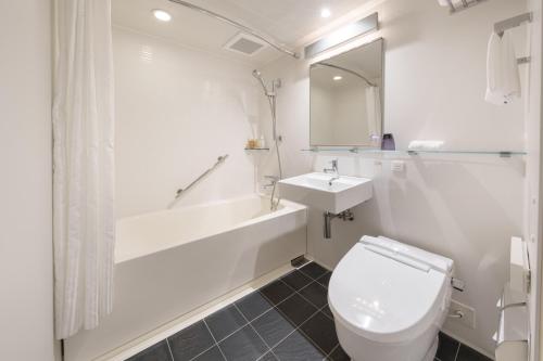 a bathroom with a toilet and a sink and a bath tub at Hotel Forza Oita in Oita