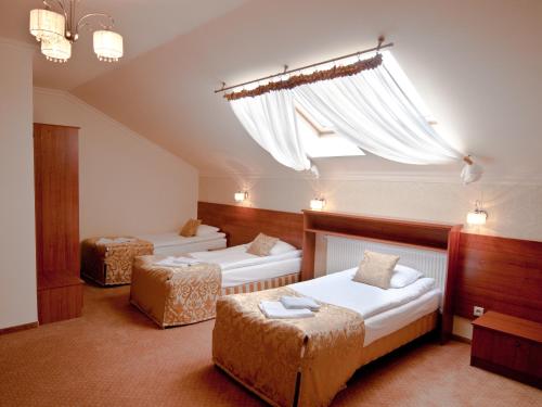 Un dormitorio con dos camas y una gran ventana. en Villa Anna, en Tarnobrzeg
