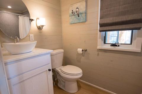 a bathroom with a toilet and a sink and a window at Point Sebago Resort in Casco
