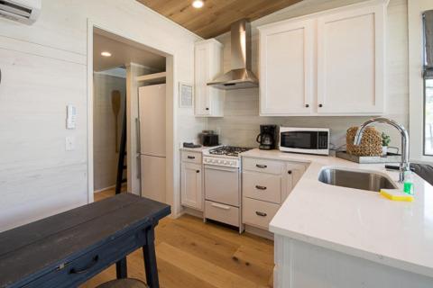 a kitchen with white cabinets and a sink and a counter at Point Sebago Resort in Casco