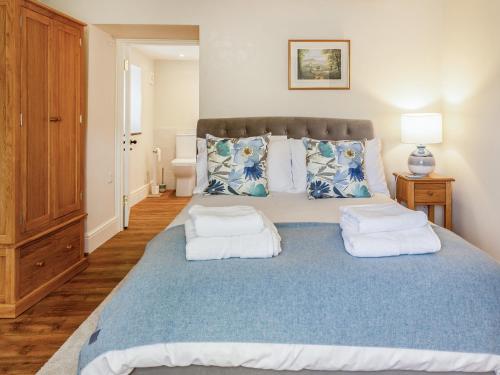 Lower Barrowfield Farm في بيمينستر: غرفة نوم بسرير ازرق كبير مع وسادتين