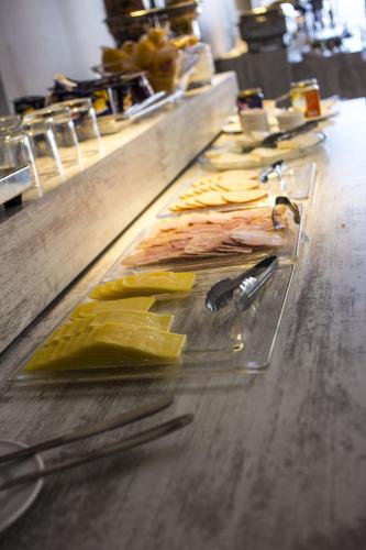 a buffet line with meat and bananas on a counter at Hotel Las Terrazas Business in Chillán