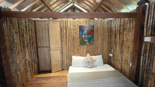 a bedroom with a bed in a bamboo wall at Village Life 