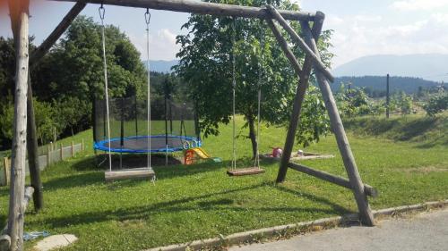 a playground in a field with swings at Apartment Beli Zajec in Mozirje