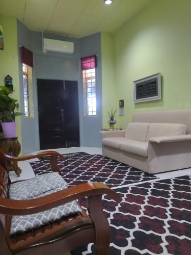 - un salon avec un canapé et un tapis dans l'établissement Singgahan Keluarga Jitu, à Jitra