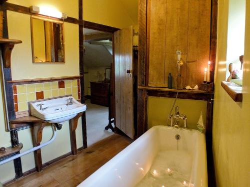 y baño con bañera y lavamanos. en Harvest Cottage en Wrexham