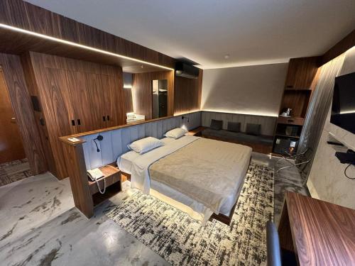 1 dormitorio con 1 cama grande y armarios de madera en Flat reformado em Hotel nos Jardins! Maravilhoso!, en São Paulo