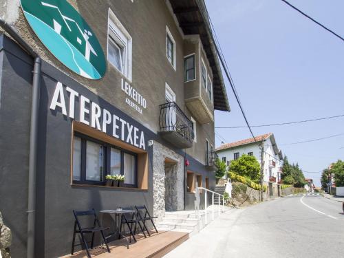 a building with a table and chairs outside of it at Lekeitio Aterpetxea Hostel in Lekeitio