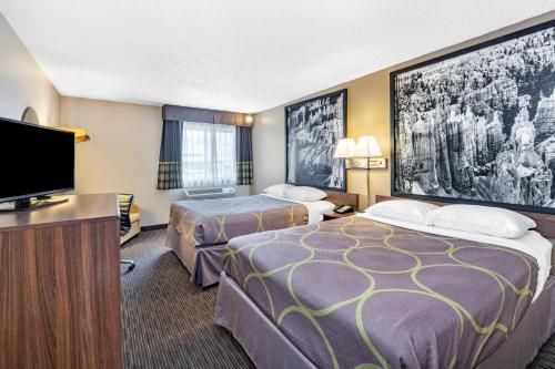 a hotel room with two beds and a flat screen tv at Super 8 by Wyndham Richfield UT in Richfield