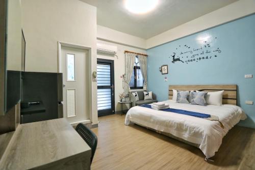 - une chambre dotée d'un lit avec un mur bleu dans l'établissement Wanghong Homestay, à Hengchun Old Town