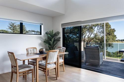 a kitchen and dining room with a table and chairs at Okiwi Landing in Raglan