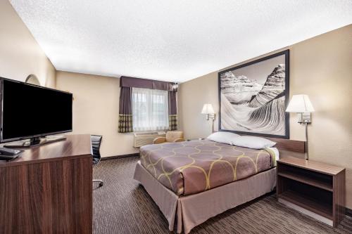 a hotel room with a bed and a flat screen tv at Super 8 by Wyndham Richfield UT in Richfield