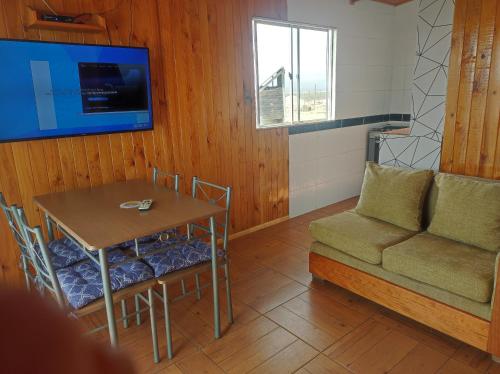 a living room with a table and a couch at Cabaña2 Punta de Choros in Choros