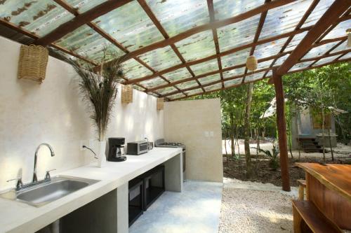 an outdoor kitchen with a pergola and a sink at Magical jungle Eco Cabana -Tulum in Macario Gomez