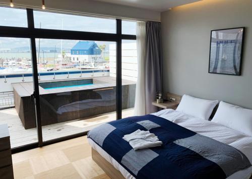 1 dormitorio con cama y vistas a la piscina en Osaka Hokko Marina HULL, en Osaka