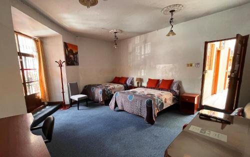 a bedroom with two beds and a couch at Hostal Benalcazar in Quito