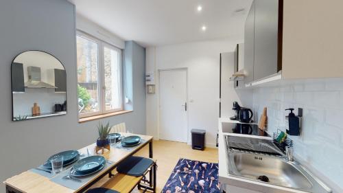 - une cuisine avec une table et un évier dans l'établissement A l'abri du tumulte de la ville, à Charleville-Mézières