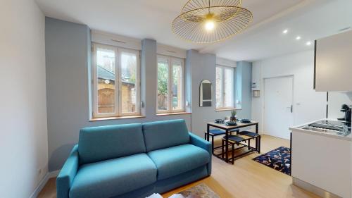 uma sala de estar com um sofá azul e uma mesa em A l'abri du tumulte de la ville em Charleville-Mézières
