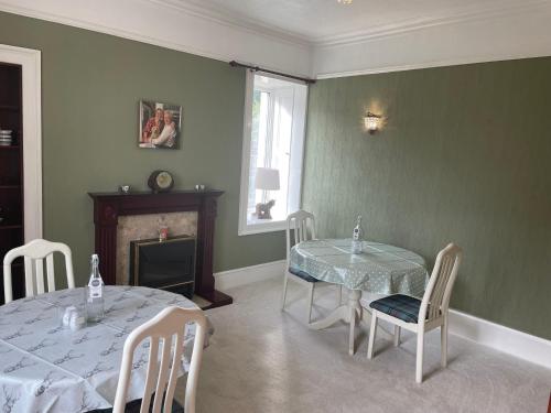 a dining room with a table and chairs and a fireplace at The Old Manse B&B in Thurso