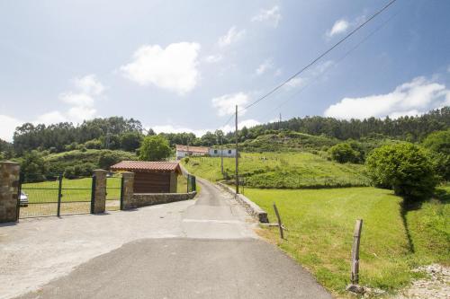 an empty road in a field with a fence at Lekeitio Aterpetxea Hostel in Lekeitio