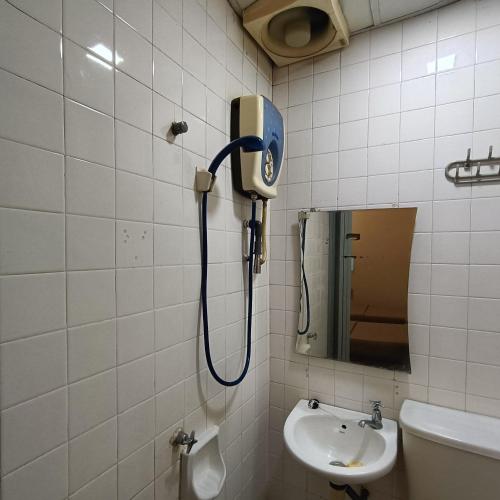 a shower in a bathroom with a sink and a mirror at Park City Motel in Melaka
