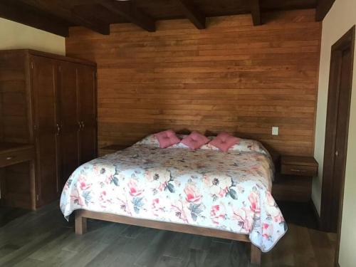 - une chambre avec un lit et des oreillers roses dans l'établissement Cabaña Luz 2, à Mazamitla