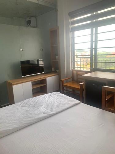 1 dormitorio con 1 cama y cocina con ventana en Nhà Nghỉ Đảo Yến 