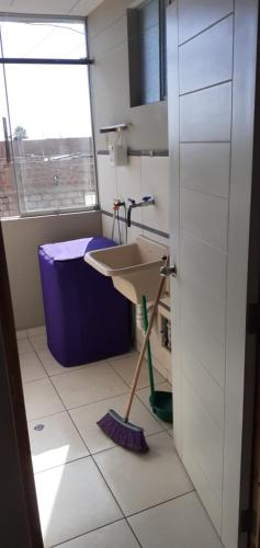 a bathroom with a sink and a broom at Apart Hotel Costa Verde in Tacna